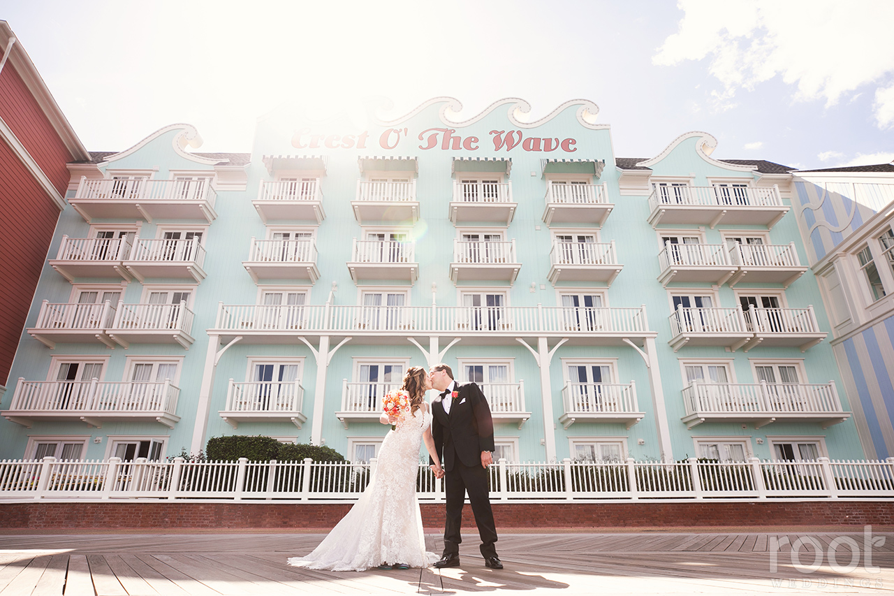 Bride and groom kissing at Disney's Boardwalk Inn Crest of the Wave Building